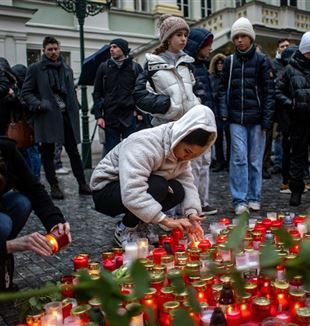 Mensen in Praag betuigen hun respect aan de slachtoffers op de plaats van het bloedbad (foto Ansa/Epa/Martin Divisek)