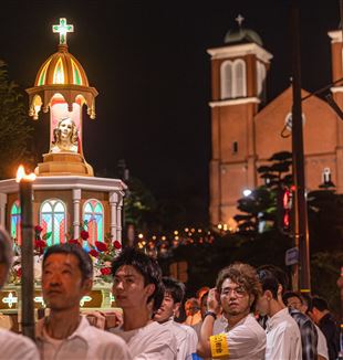 Fakkeltocht naar het Nagasaki Peace Park. Op de achtergrond de Urakami-kathedraal, herbouwd en ingewijd in 1959, op de plaats van de op 9 augustus 1945 verwoeste oorspronkelijke kathedraal(© Mihoko Owada / Catholic Standard)
