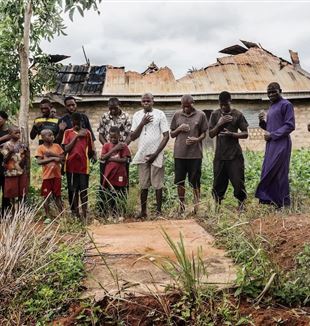 Er wordt gebeden bij een massagraf in Yelwata (Centraal-Nigeria). De slachtoffers werden in juni 2025 met machetes afgeslacht door Fulani-herders. (©Carlo Cozzoli)