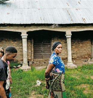 Inwoners van Yelwatain voor een huis dat door de Fulani is verwoest (© Carlo Cozzoli).