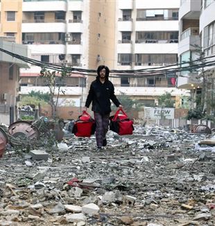 Een man op de vlucht tijdens de bomaanslagen in Beiroet (© Ansa/Epa/Wael Hhamzeh)