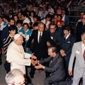 Don Giussani knielt bij de aankomst van Johannes Paulus II op de Meeting in de zomer van 1982. Links van de paus staat Emilia Guarnieri (© Meeting Rimini)